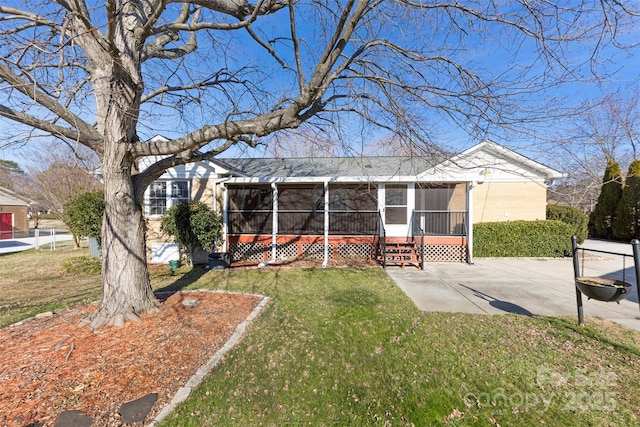 view of front of house featuring a front yard, a patio area, and a sunroom