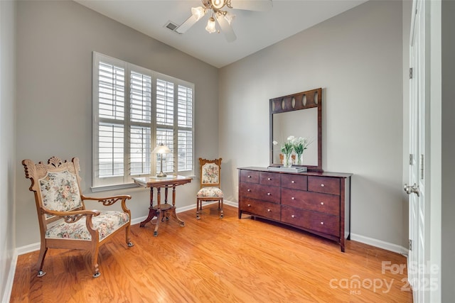 living area with ceiling fan and light hardwood / wood-style flooring