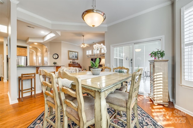 dining room featuring ceiling fan, crown molding, and light wood-type flooring