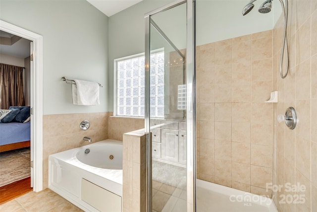 bathroom featuring tile patterned flooring and shower with separate bathtub