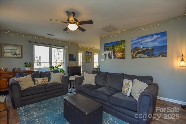 living room featuring ceiling fan and dark wood-type flooring