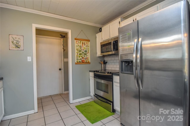 kitchen featuring light tile patterned floors, appliances with stainless steel finishes, backsplash, ornamental molding, and white cabinets