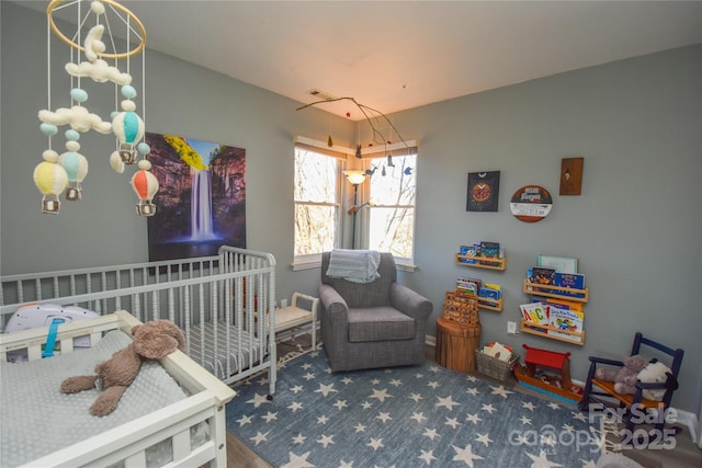 bedroom featuring lofted ceiling and a crib