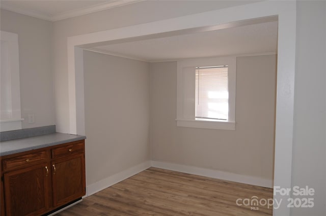 interior space featuring crown molding and light hardwood / wood-style floors