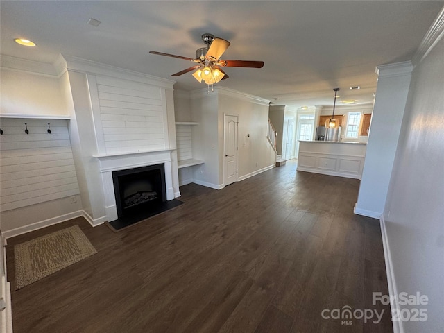 unfurnished living room with dark wood-type flooring, ornamental molding, and ceiling fan