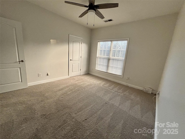 empty room featuring ceiling fan and light carpet