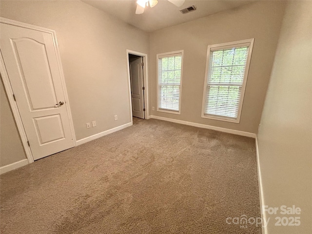 interior space with ceiling fan and light colored carpet