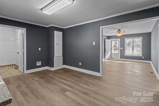 empty room with ceiling fan, ornamental molding, and light wood-type flooring