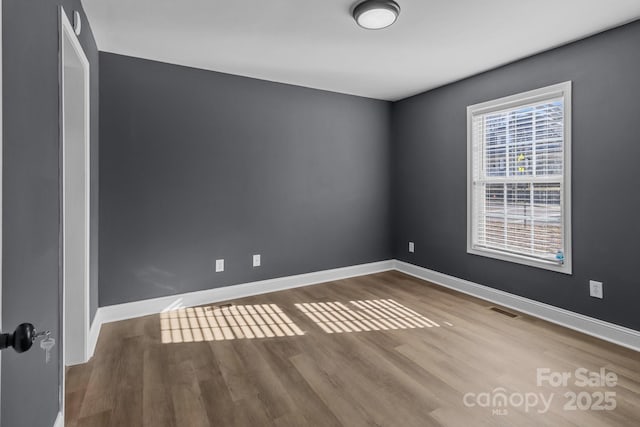 unfurnished room with hardwood / wood-style floors