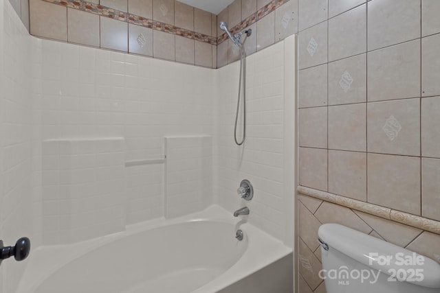 bathroom featuring shower / bathing tub combination, tile walls, and toilet