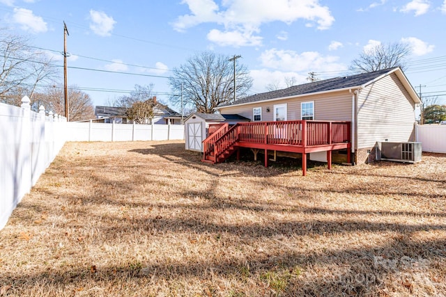 rear view of property with central AC unit, a storage unit, a deck, and a lawn