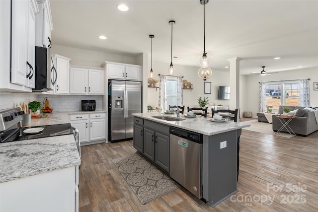 kitchen featuring white cabinetry, appliances with stainless steel finishes, sink, and an island with sink