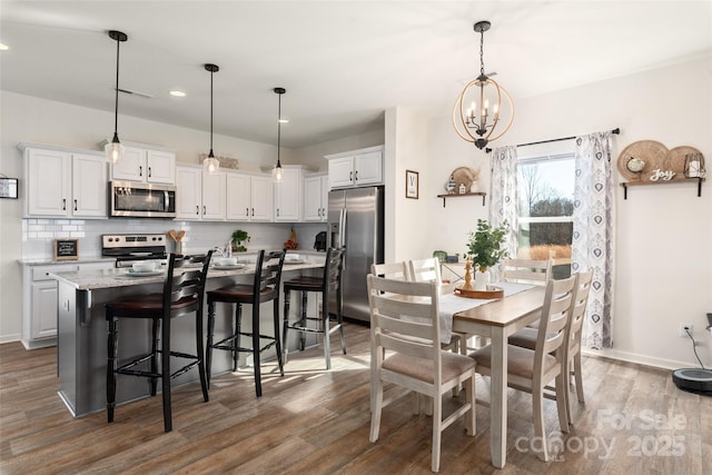 dining room with dark hardwood / wood-style flooring and a notable chandelier