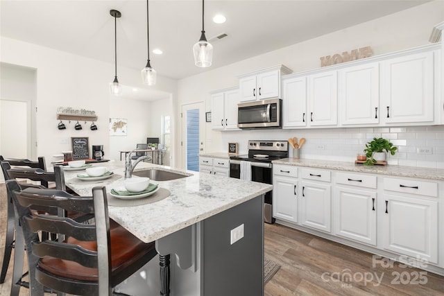 kitchen featuring appliances with stainless steel finishes, a breakfast bar, and white cabinets