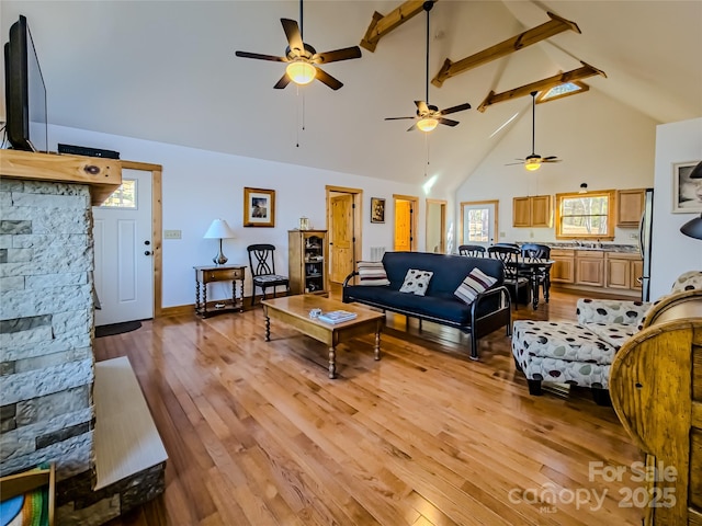 living room with beam ceiling, ceiling fan, high vaulted ceiling, and light hardwood / wood-style flooring