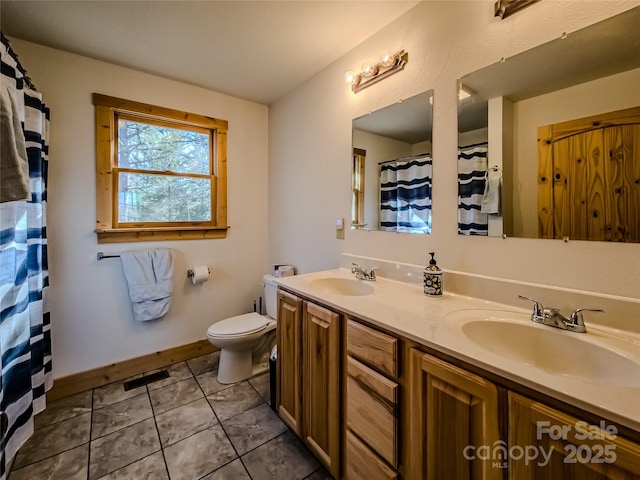 bathroom featuring tile patterned flooring, vanity, and toilet