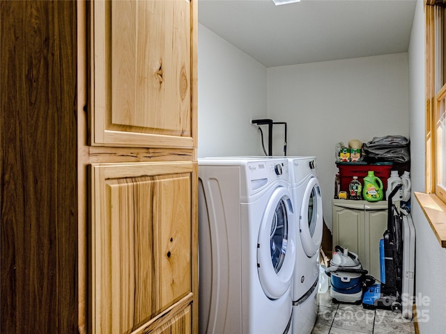 laundry room with cabinets, light tile patterned flooring, and washer and clothes dryer