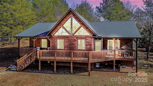 back house at dusk with a wooden deck