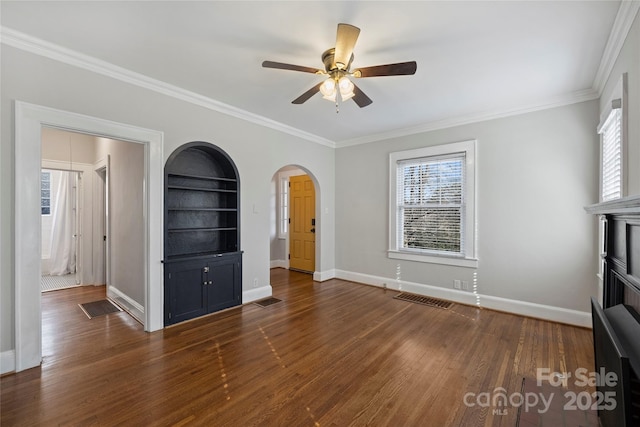 unfurnished living room with crown molding, ceiling fan, built in features, and dark hardwood / wood-style flooring