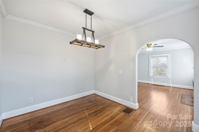 unfurnished dining area with ornamental molding, wood-type flooring, and ceiling fan with notable chandelier