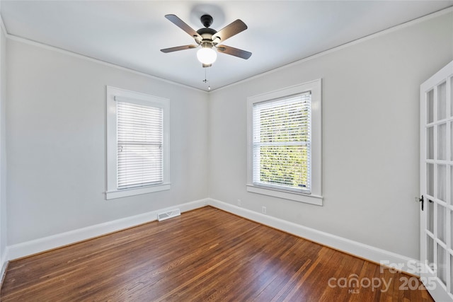 empty room featuring ceiling fan, ornamental molding, and dark hardwood / wood-style flooring