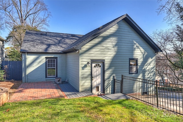 back of house featuring a lawn and a patio