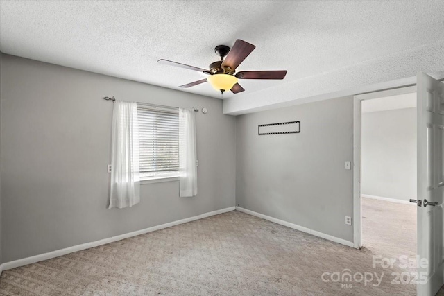 carpeted spare room with ceiling fan and a textured ceiling