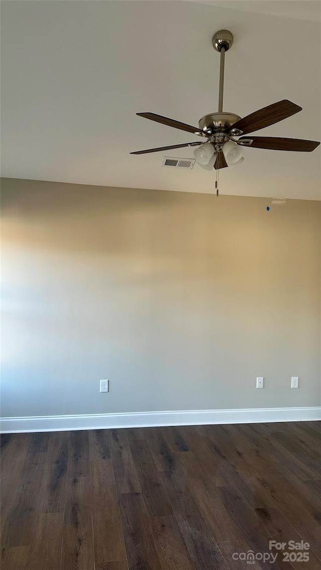 spare room with dark wood-type flooring and ceiling fan