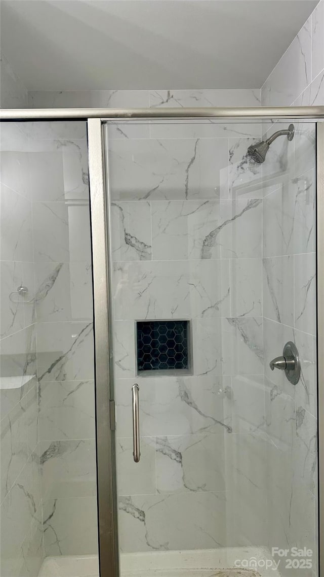 bathroom featuring a shower with door