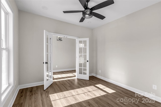 empty room with ceiling fan, wood-type flooring, and french doors