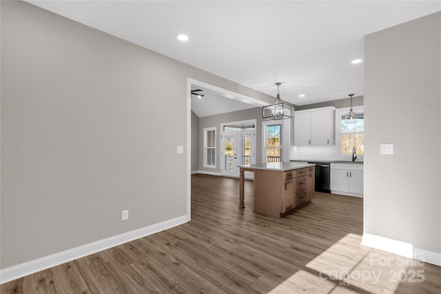 kitchen with dishwasher, pendant lighting, a kitchen island, white cabinets, and french doors