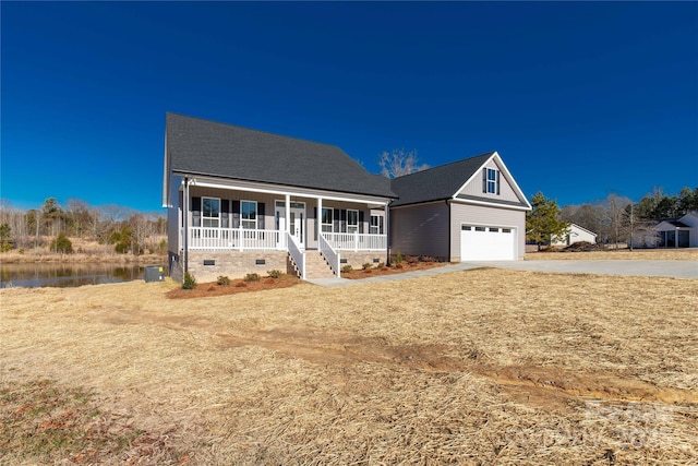 view of front of property featuring a water view, covered porch, and a garage