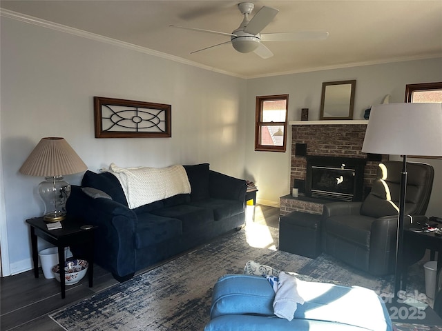 living room featuring ceiling fan, a brick fireplace, crown molding, and dark hardwood / wood-style floors