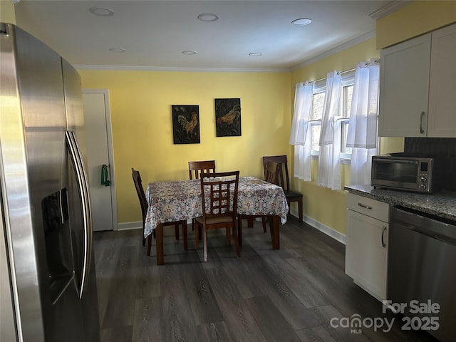 dining area featuring dark wood-type flooring and crown molding