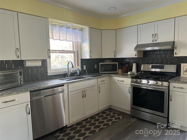 kitchen featuring backsplash, sink, white cabinets, and appliances with stainless steel finishes