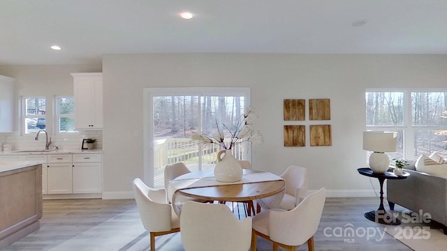 dining area with plenty of natural light, sink, and light hardwood / wood-style floors