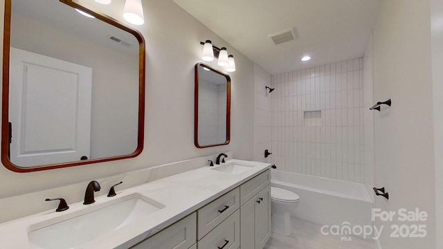 full bathroom featuring vanity, tiled shower / bath, and toilet