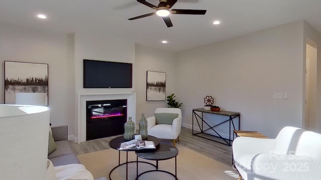 living room with ceiling fan and light hardwood / wood-style floors