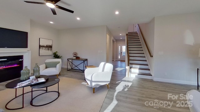 living room featuring ceiling fan and light wood-type flooring