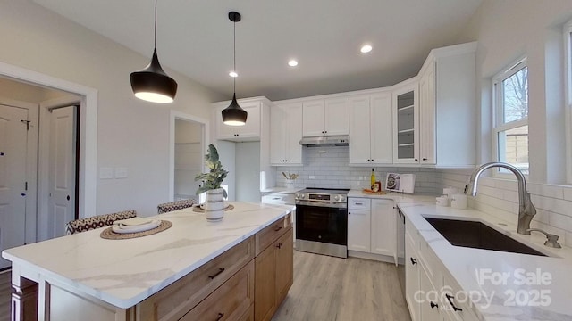 kitchen featuring sink, electric range, a center island, light stone counters, and white cabinets