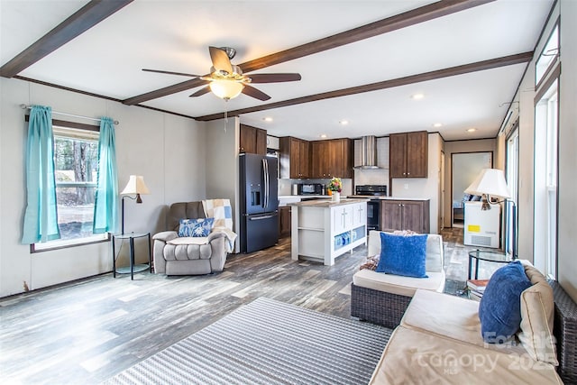 living room featuring ceiling fan, wood-type flooring, and beamed ceiling