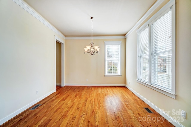 unfurnished dining area featuring ornamental molding, light wood-style flooring, visible vents, and baseboards