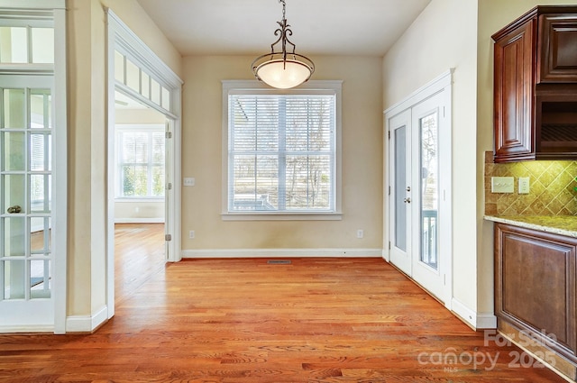 entryway with visible vents, light wood-style flooring, and baseboards