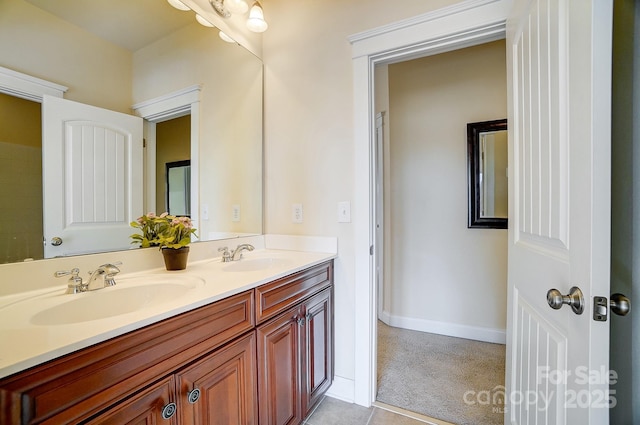 full bathroom featuring a sink, baseboards, and double vanity