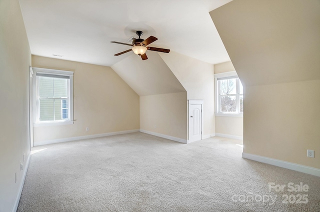 additional living space featuring light carpet, ceiling fan, lofted ceiling, and baseboards