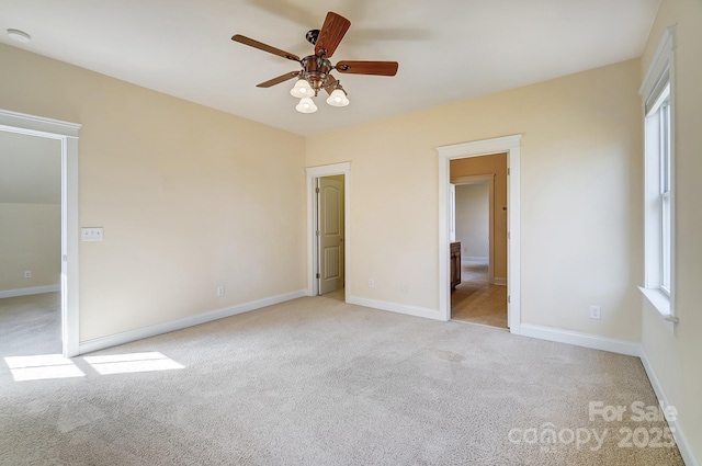 unfurnished bedroom featuring a ceiling fan, light colored carpet, and baseboards