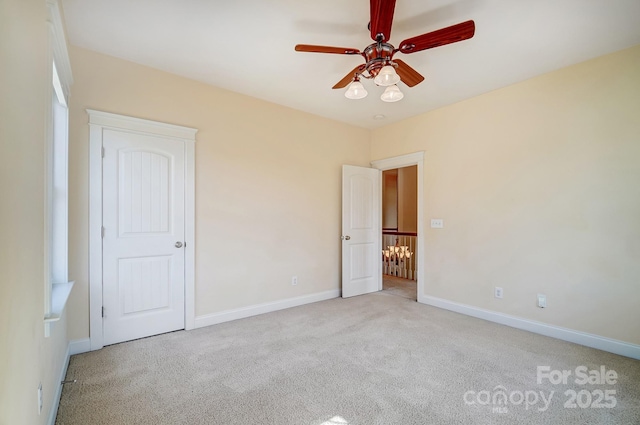 unfurnished bedroom featuring light carpet, ceiling fan, and baseboards