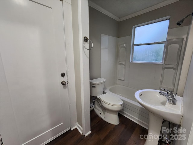 bathroom with hardwood / wood-style flooring, washtub / shower combination, toilet, and crown molding