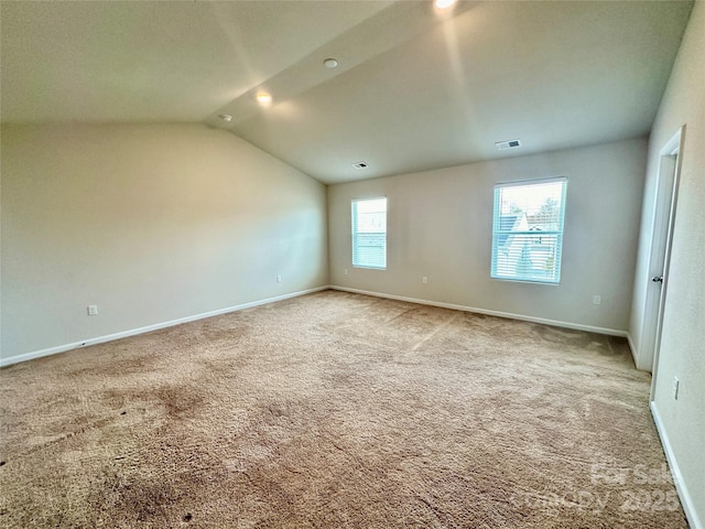 carpeted empty room featuring lofted ceiling