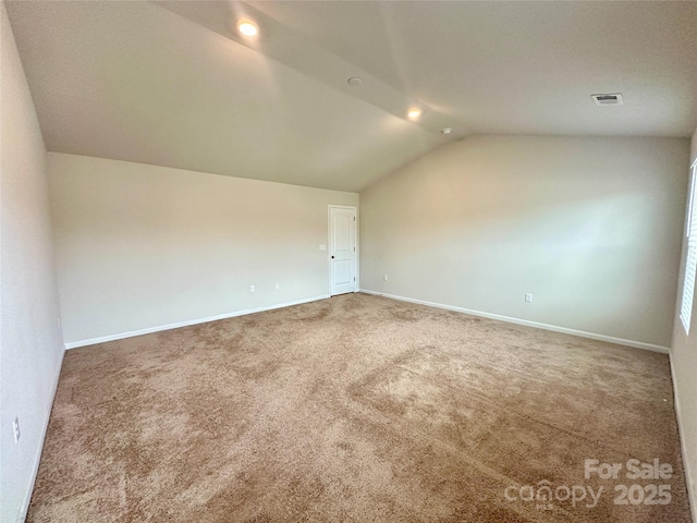 additional living space with vaulted ceiling and carpet flooring